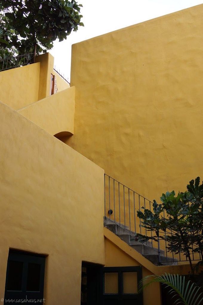 résidence privée murs jaunes escalier métallique noir déco extérieure