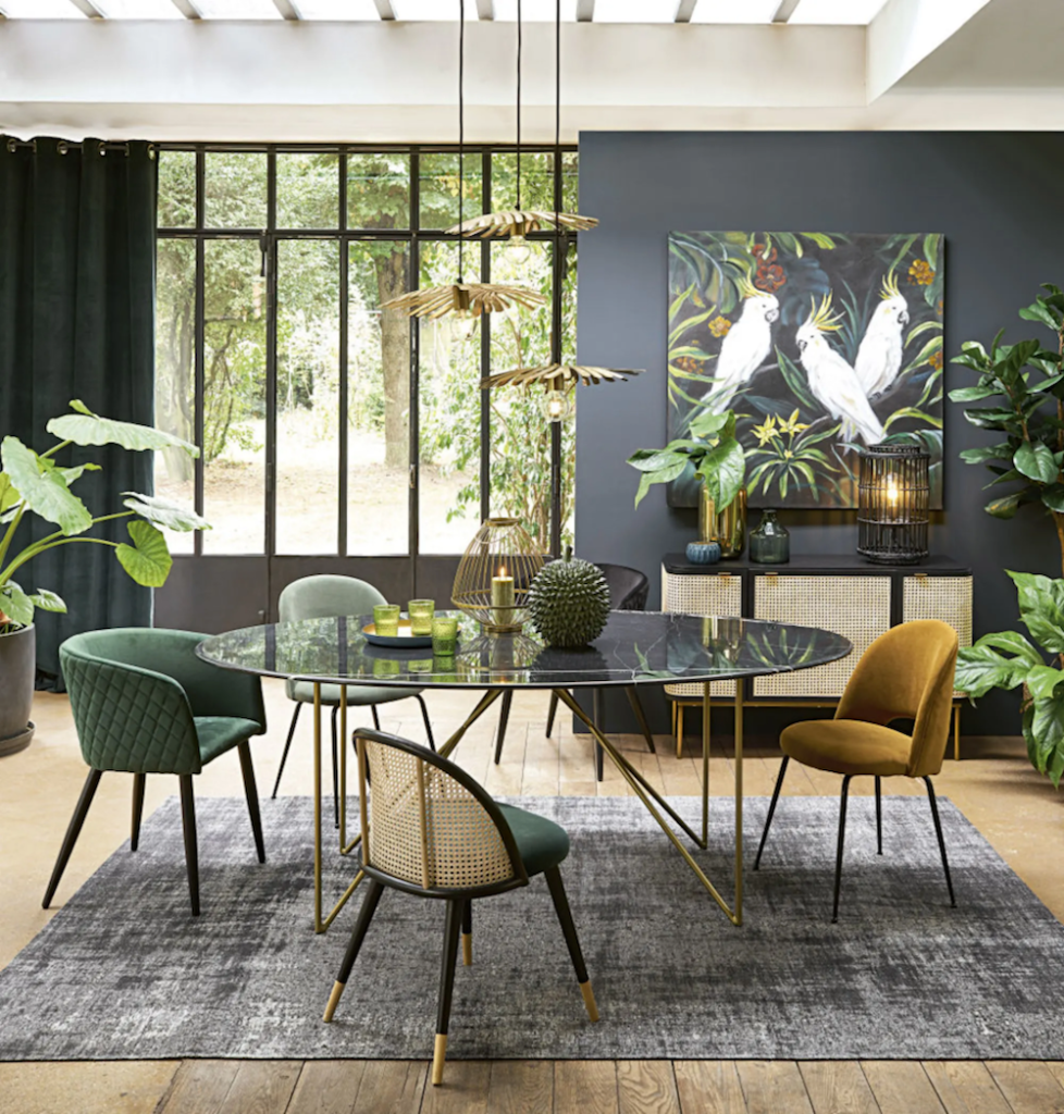 salle à manger urban jungle table ronde suspension en laiton chaises dépareillées tapis gris