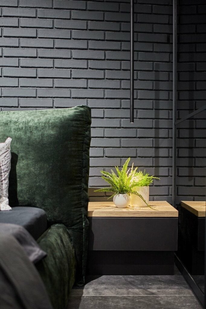 chambre lit velours vert mur briques noires déco masculine