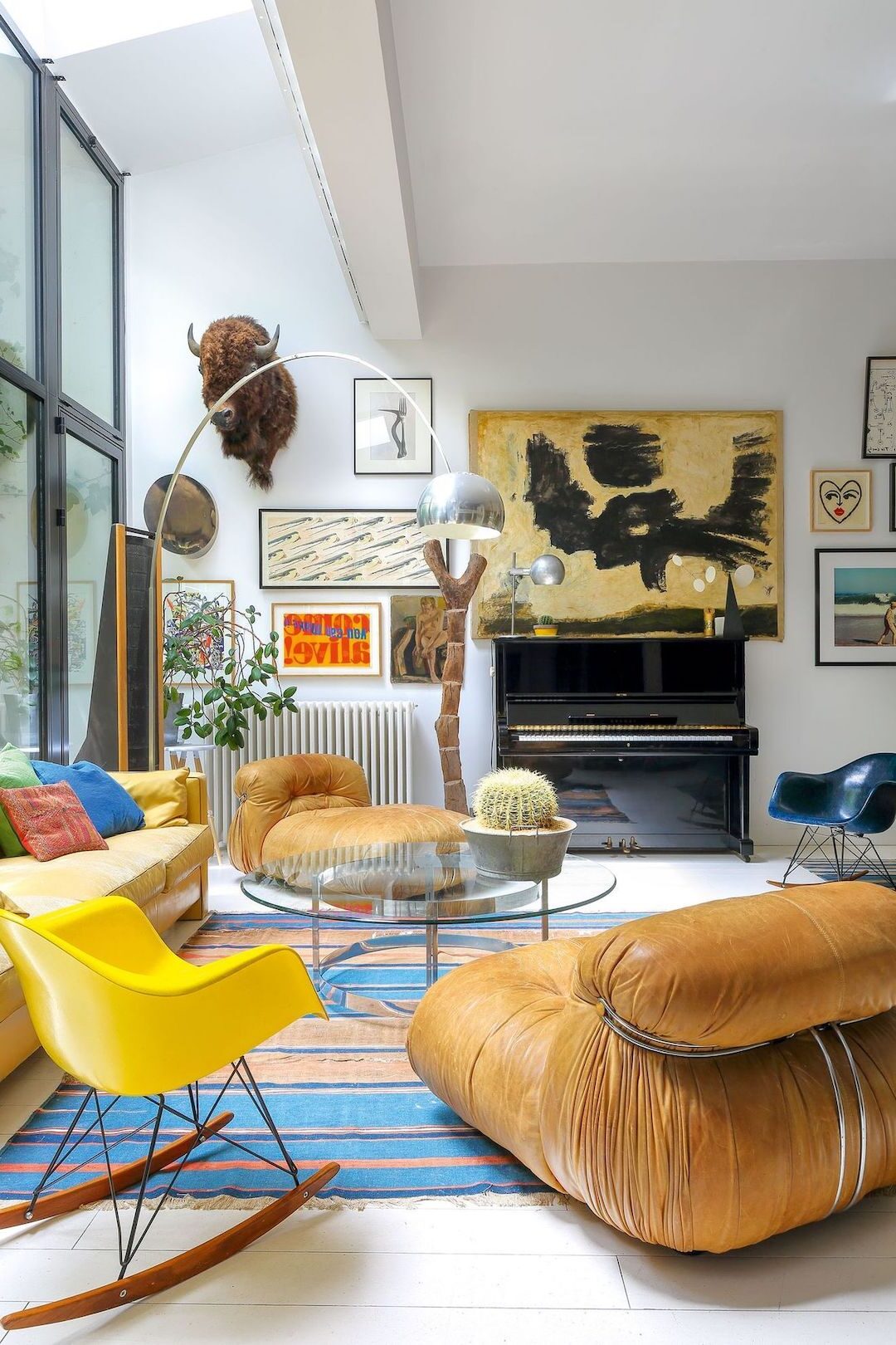 salon lumineux spacieux canapé cuir marron chaise scandinave jaune tapis bleu