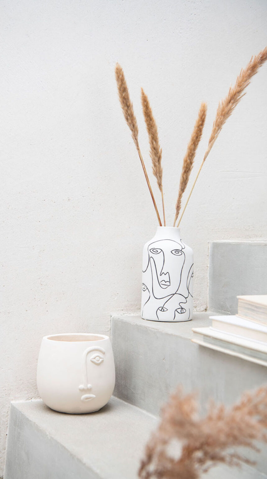 vase blanc forme visage abstrait noir herbe de la pampa marche béton gris