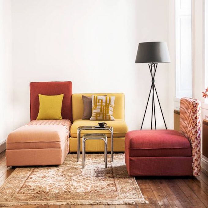 salon lumineux tapis vintage retro effet délavé canapé fauteuil carre rouge jaune parquet en bois lampe noire