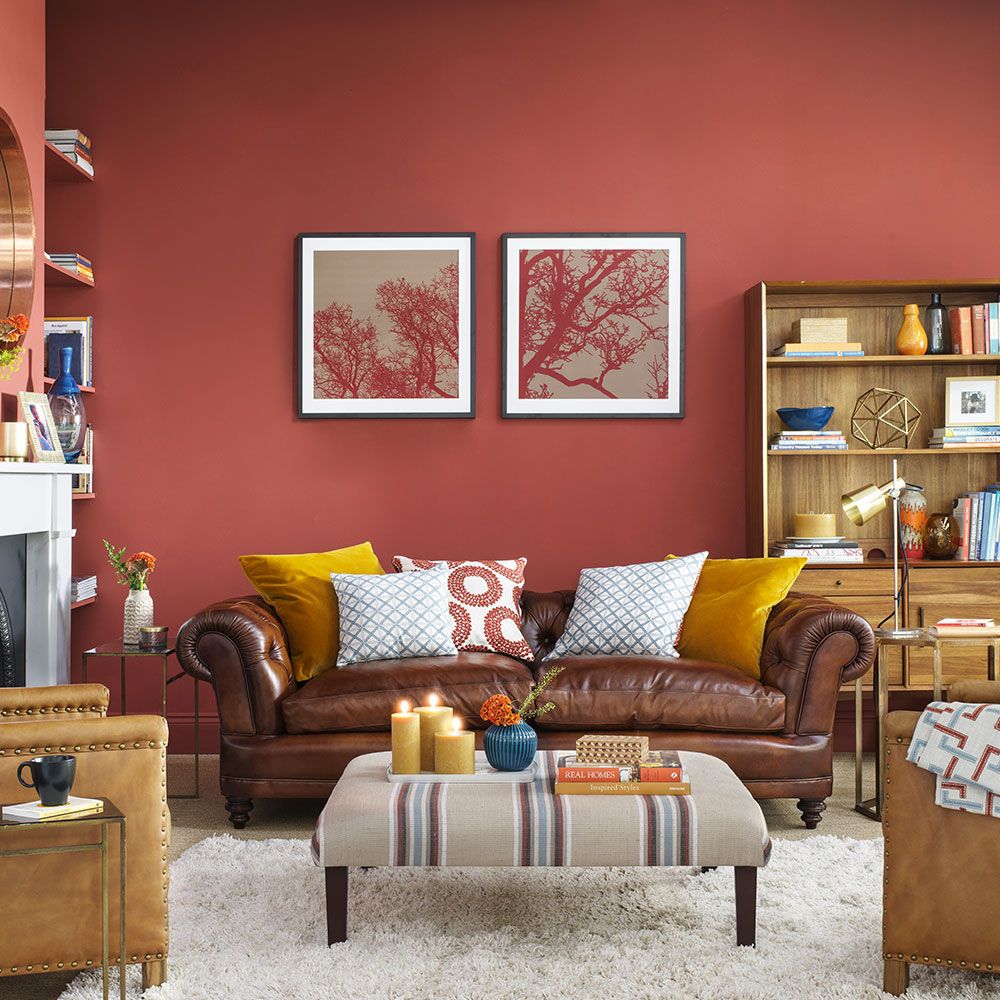 salon retro vintage canapé droit cuir marron chesterfield tapis blanc armoire bois mur rouge cadre rouge