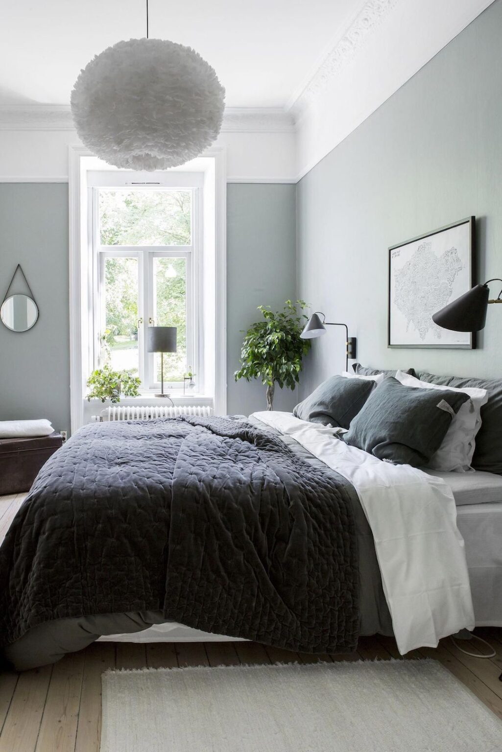 inspiration decoration intérieure lit double bleu marine mur vert sauge vert pastel parquet bois lustre rond plumes