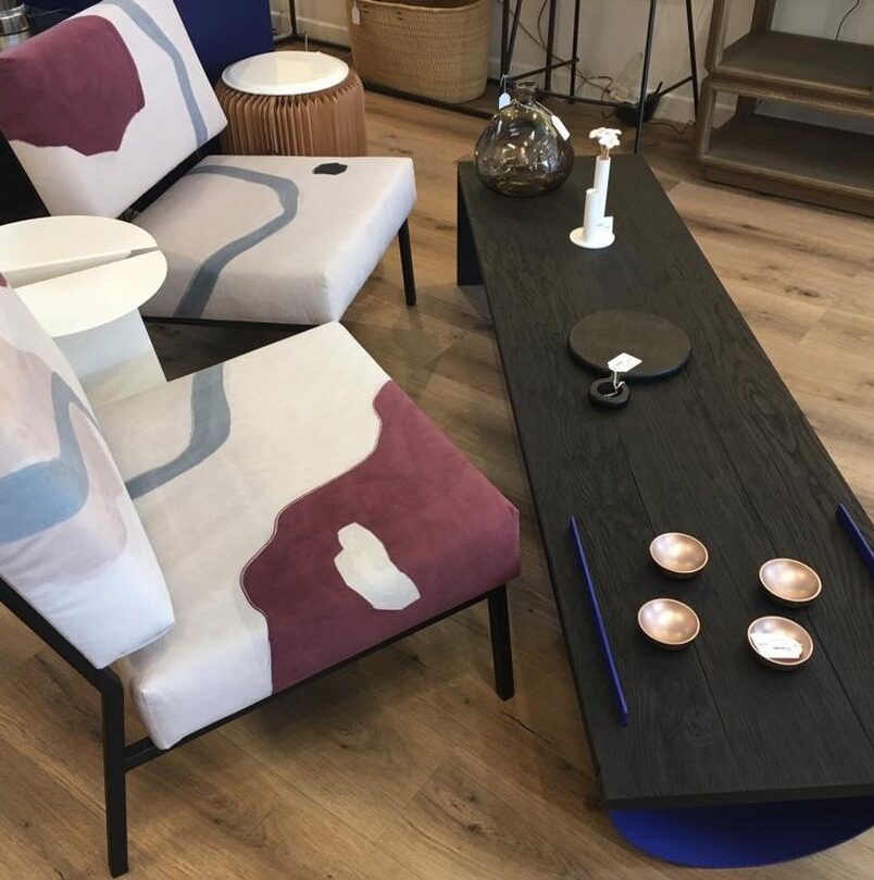 boutique salon table bois noire parquet bois fauteuil colore