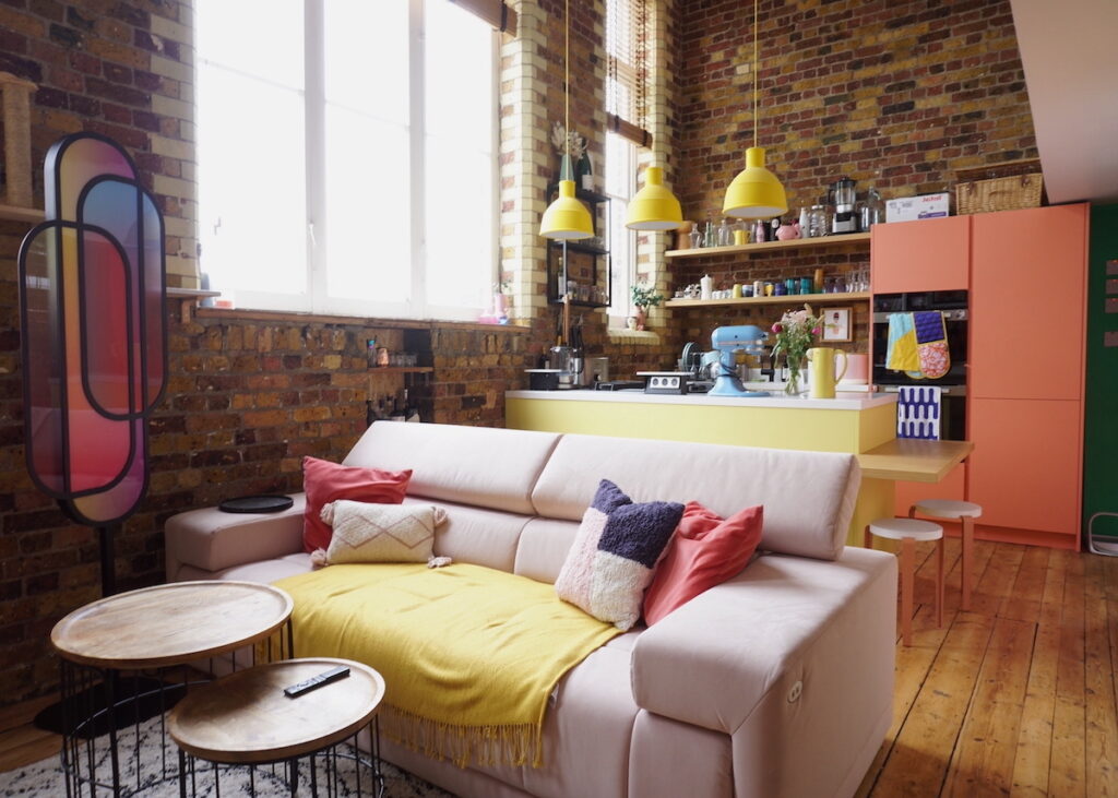 salon cuisine ouverte canape droit blanc mur brique