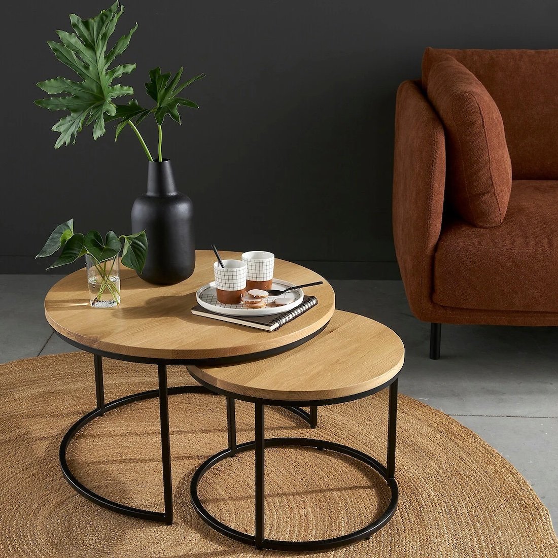 table bois ronde pieds metalliques noir canape velours orange rouge mur noir plante verte