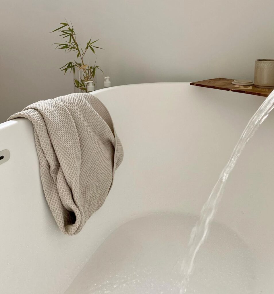 baignoire arrondie blanc serviette bain beige