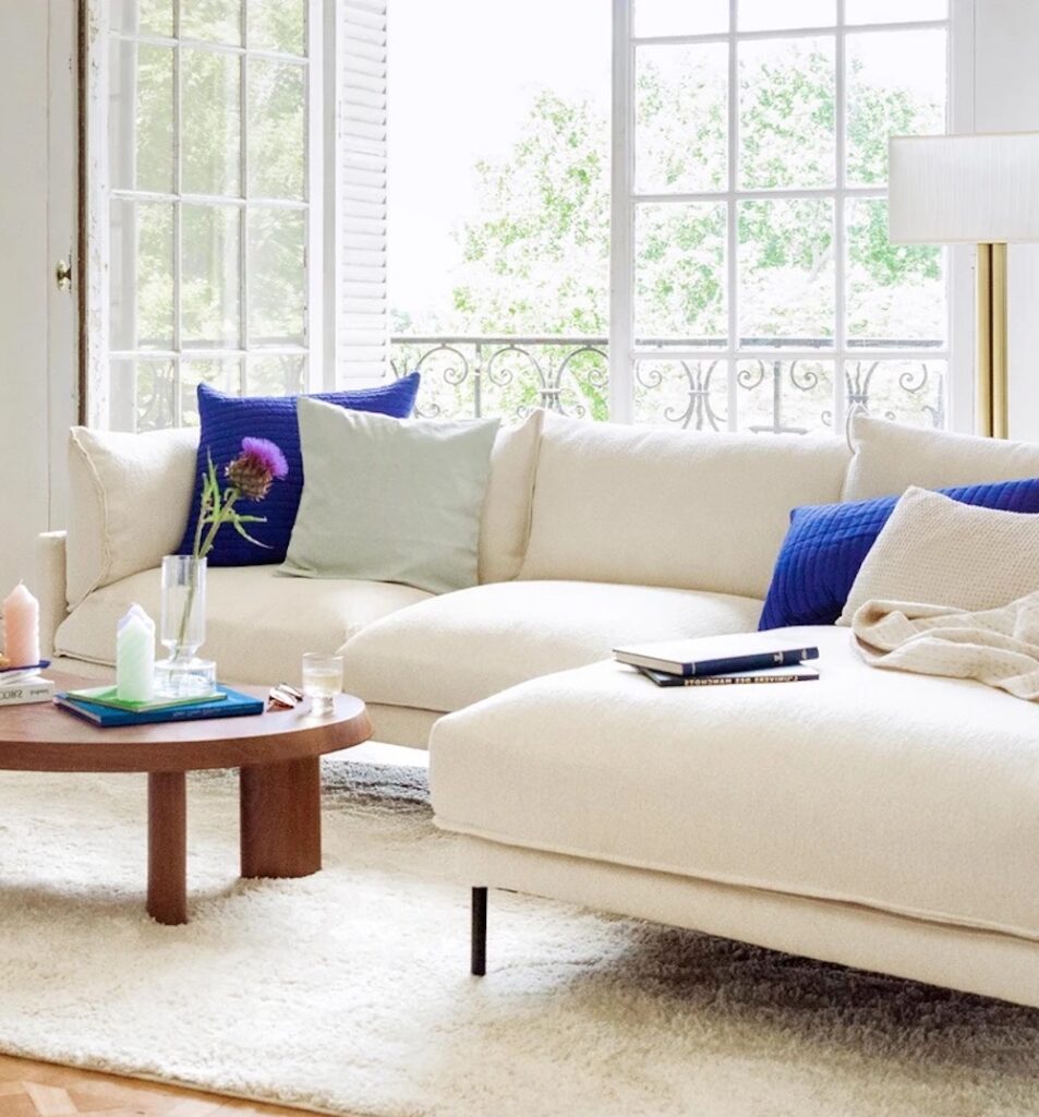 salon blanc canape d'angle coussin bleu marine table basse bois teck marron