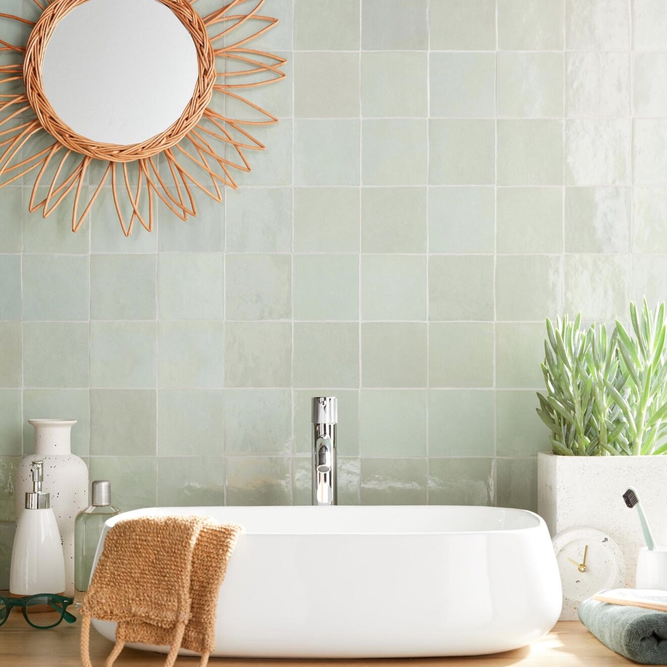 lavabo oval blanc mur carrelage vert miroir rotin