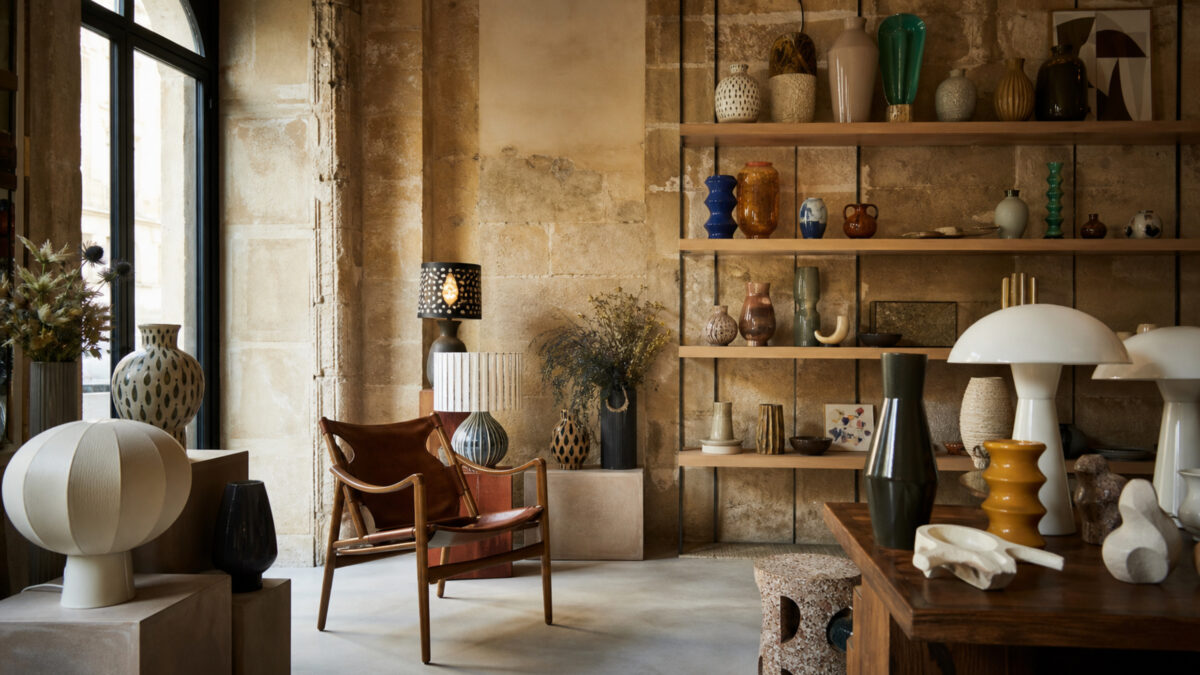 bonnes adresses déco à Bordeaux avec boutique design dans un intérieur en pierre blonde, étagères en bois, céramiques, lampes sculpturales et fauteuil vintage