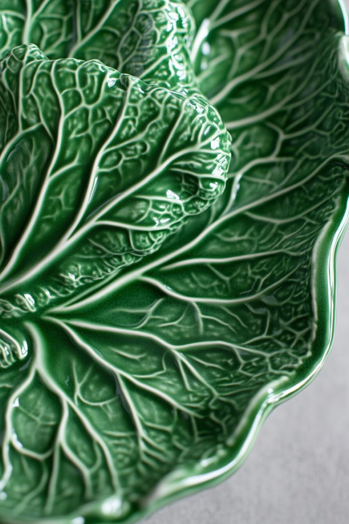 Gros plan sur une assiette feuille de chou verte émaillée avec nervures en relief et finition brillante