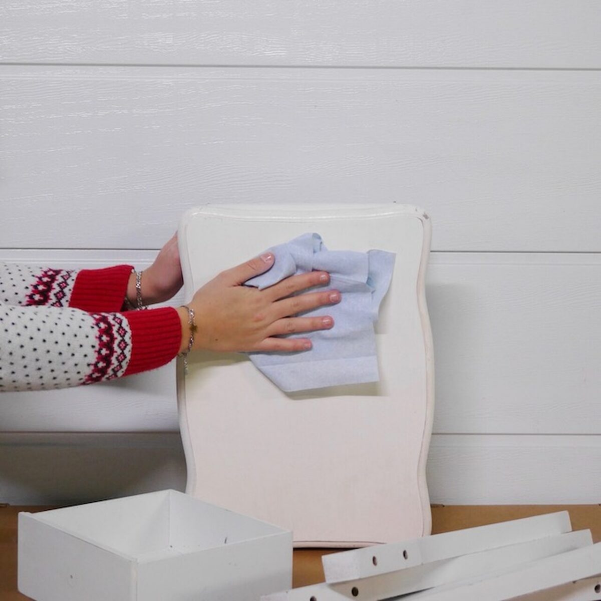 Dépoussiérage d’un panneau blanc de table de chevet avec un chiffon microfibre