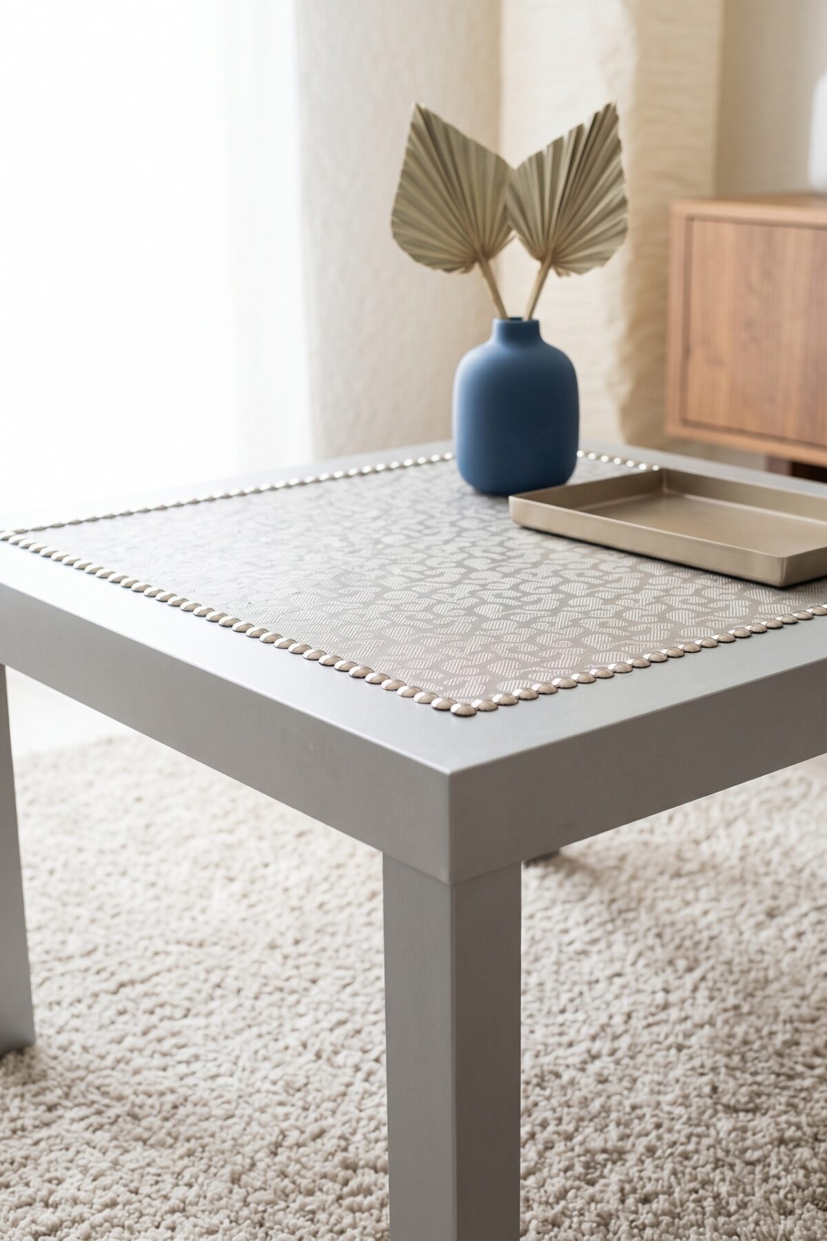 Table basse IKEA customisée avec bordure de clous de tapissier champagne