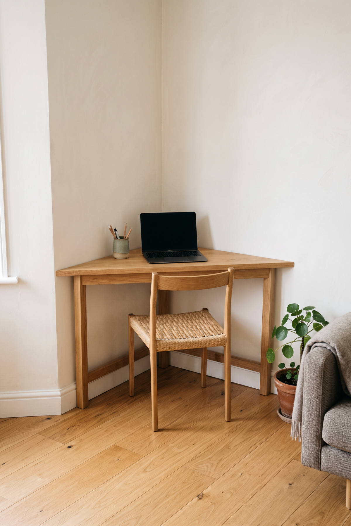 Bureau triangulaire en bois installé dans l’angle d’un salon