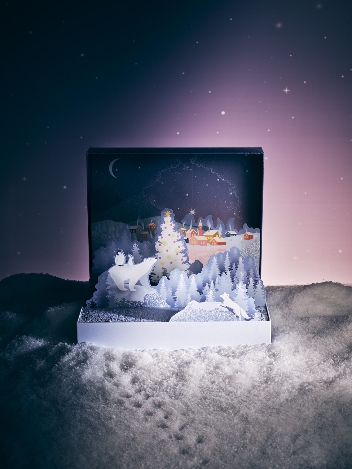 Calendrier de l’Avent Lenôtre ouvert, décoré d’un paysage polaire enneigé avec sapin, village et animaux