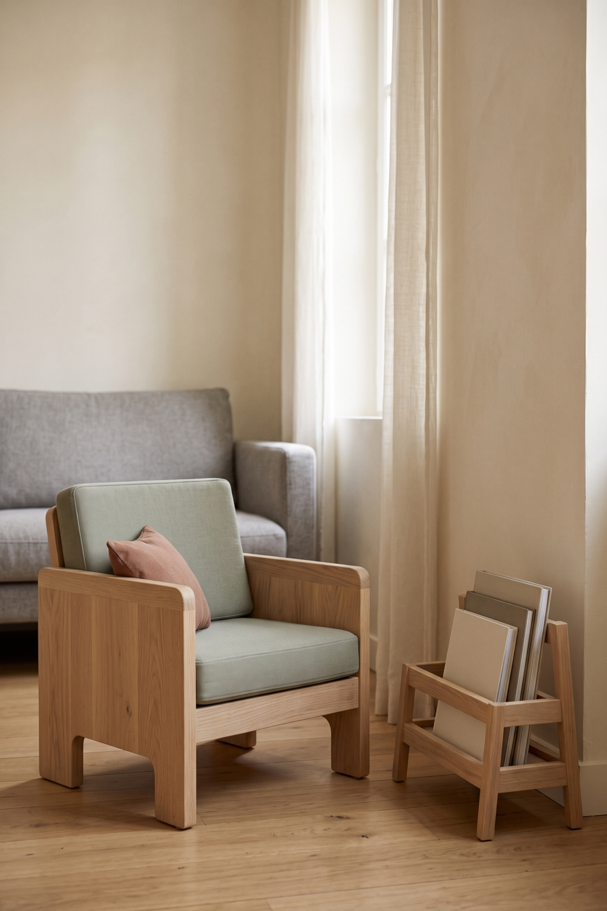 Fauteuil bas près d’un rangement de livres, éclairé par une lumière naturelle douce