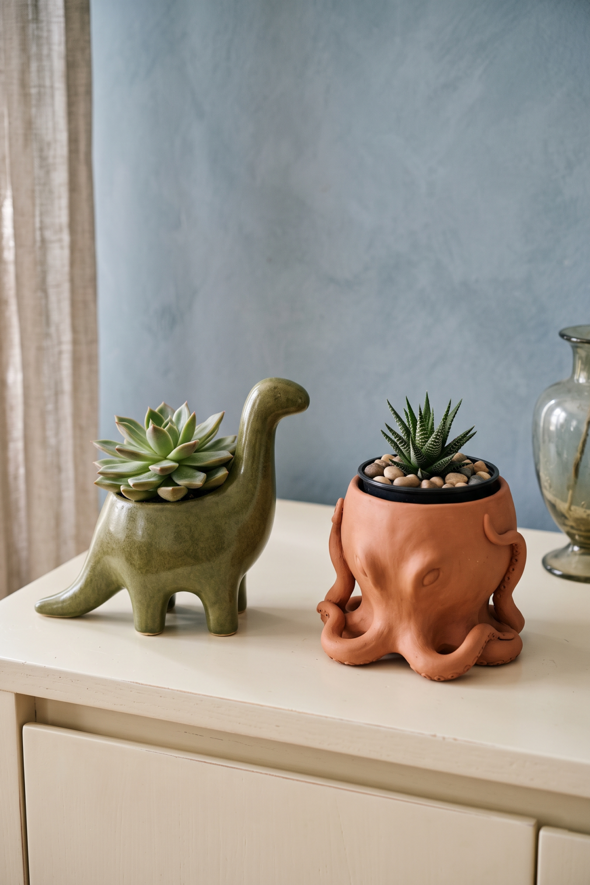 Pot dinosaure et cache-pot pieuvre pour petites plantes sur un buffet