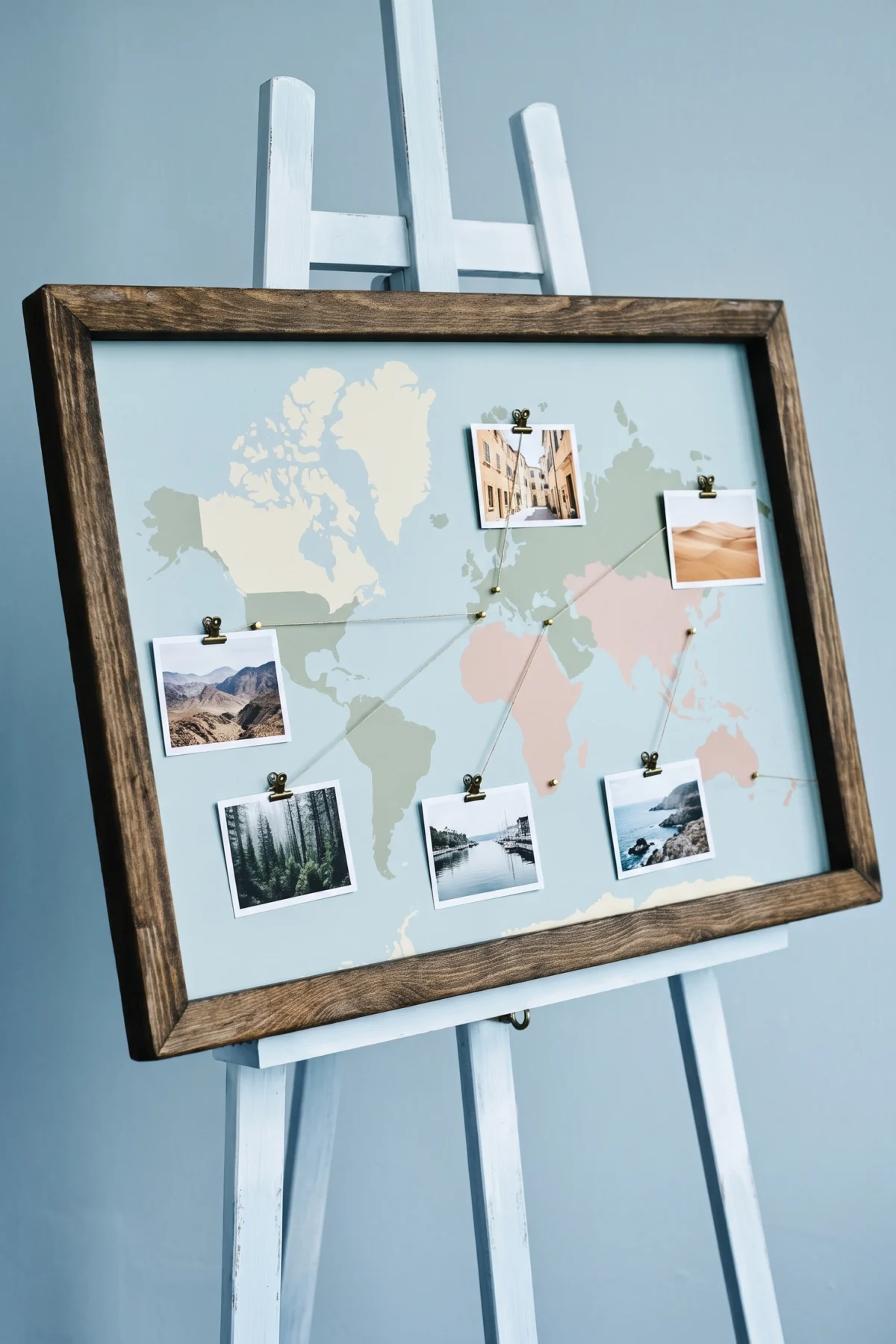 Carte du monde encadrée sur chevalet avec photographies de voyage
