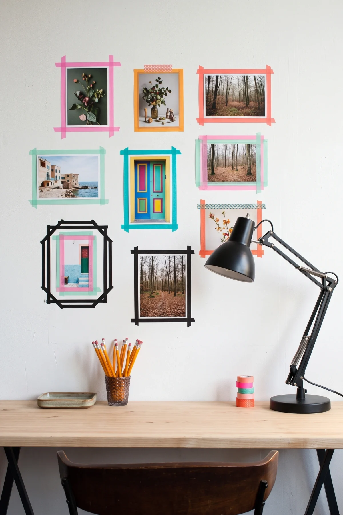Photographies encadrées de masking tape coloré au-dessus d’un bureau et d’une lampe noire